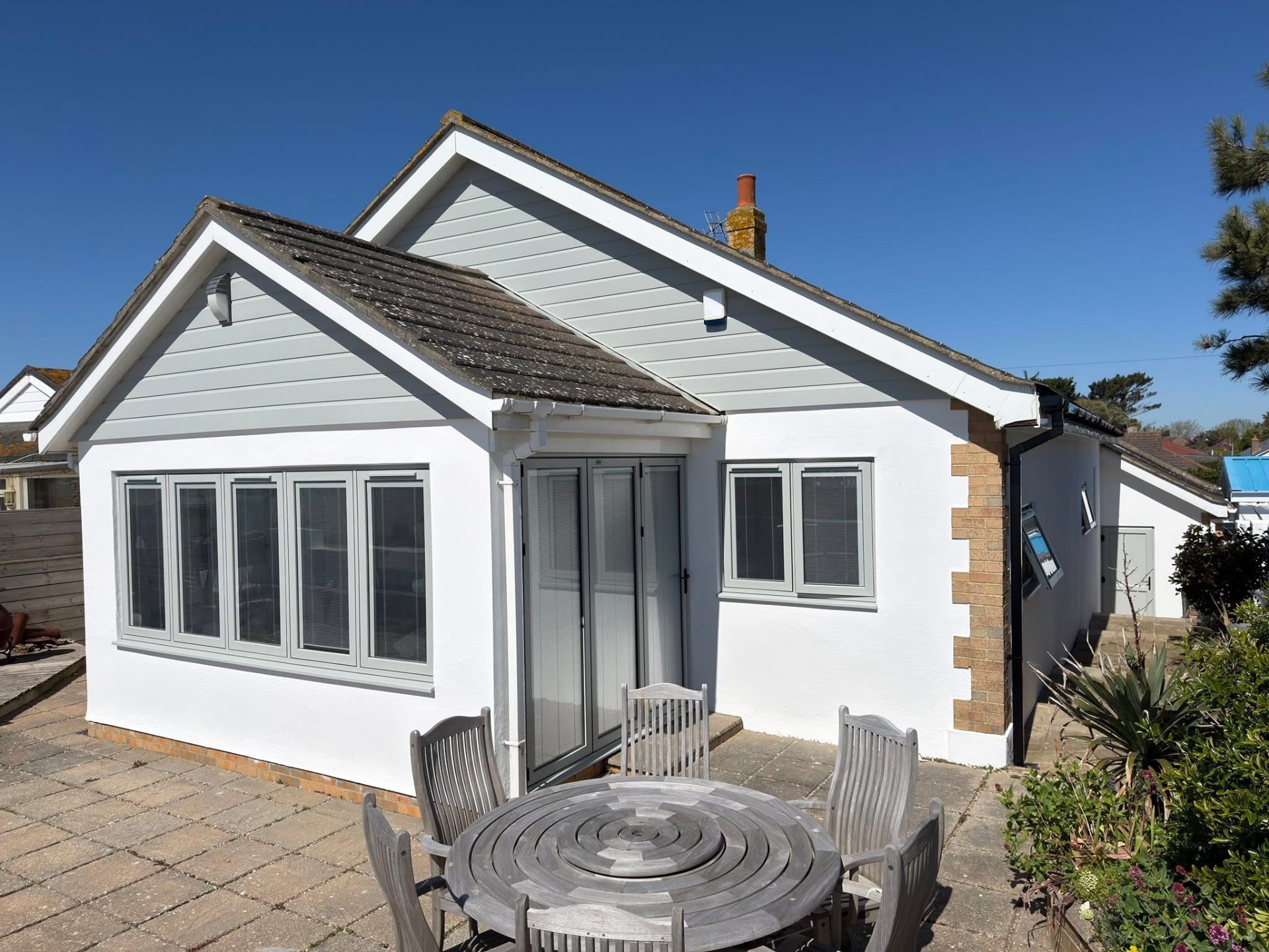Rendered bungalow exterior with freshly painted walls, cladding and fascias