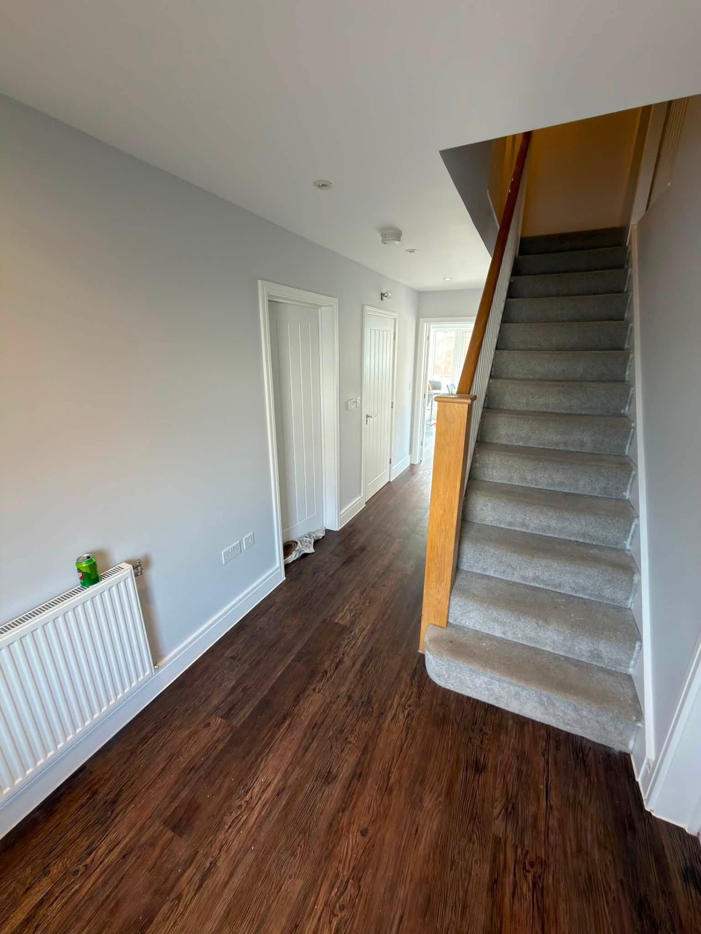 Hallway and staircase decorated in a pale grey with bright white woodwork