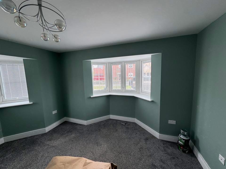 Living room with bay window decorated in a deep sage green