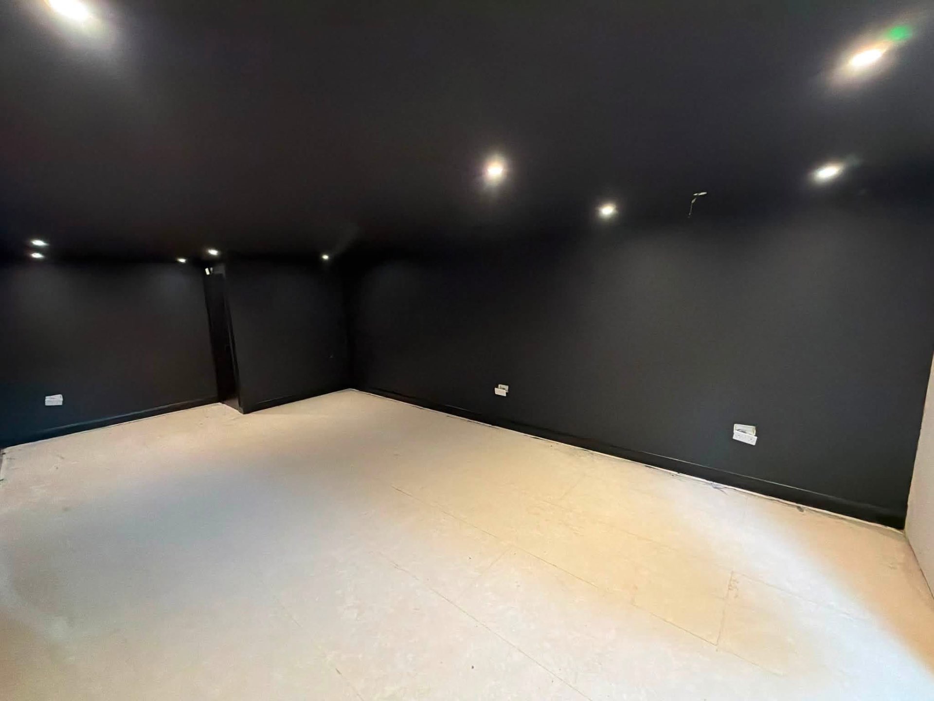 Home cinema room finished in a deep matt black with crisp cut-in lines