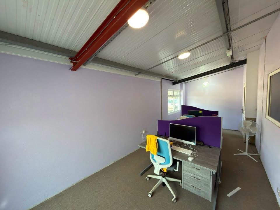 Industrial unit office decorated in soft lilac with finished steelwork above